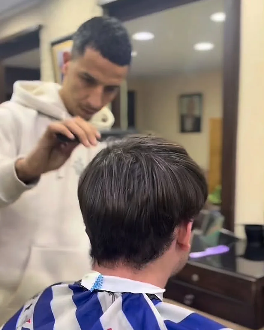 Coupe reprise au peigne et aux ciseaux devant le miroir du salon